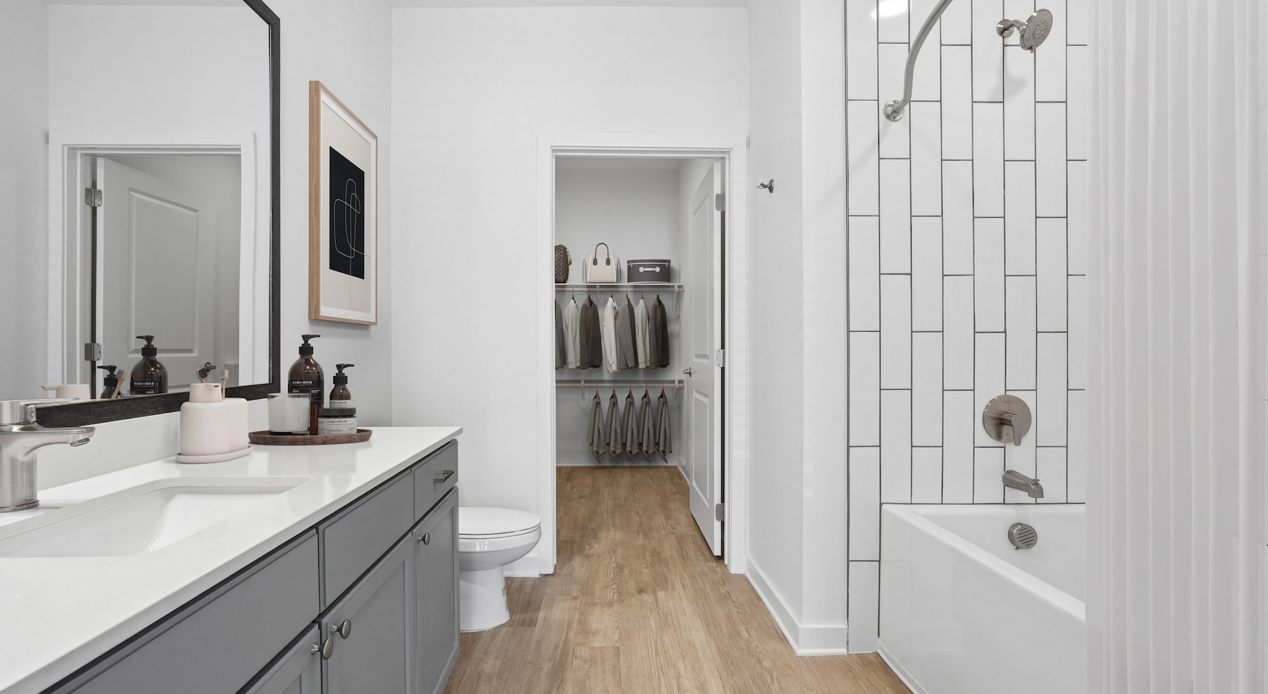 a bathroom with a sink, mirror and shower