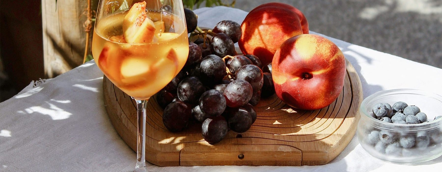 a board of fruit and a glass of wine
