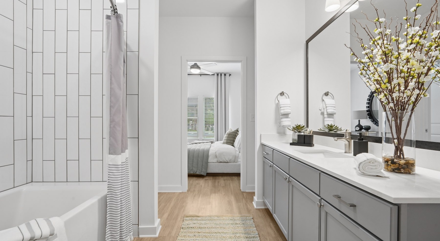a bathroom with a tub, sink and mirror